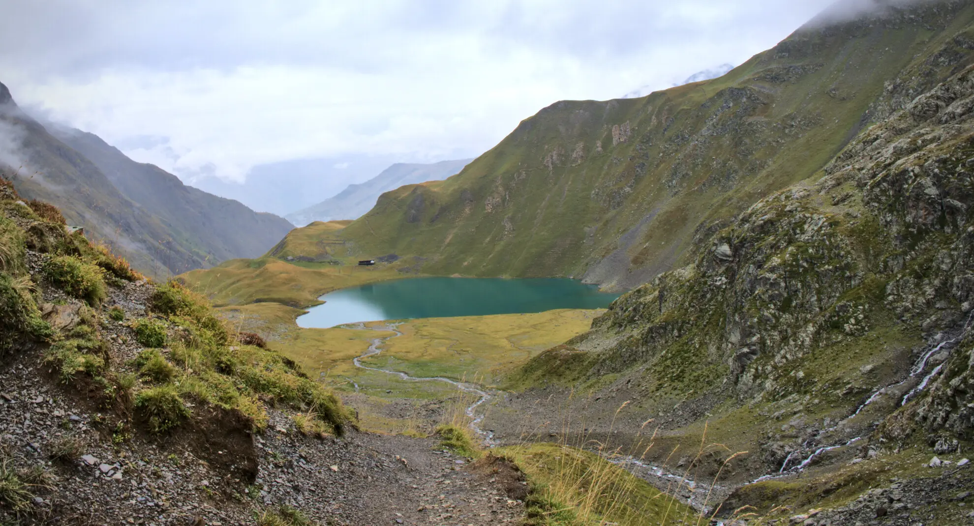 Lac de la Muzelle from the descent trail, refuge sitting at the water's edge
